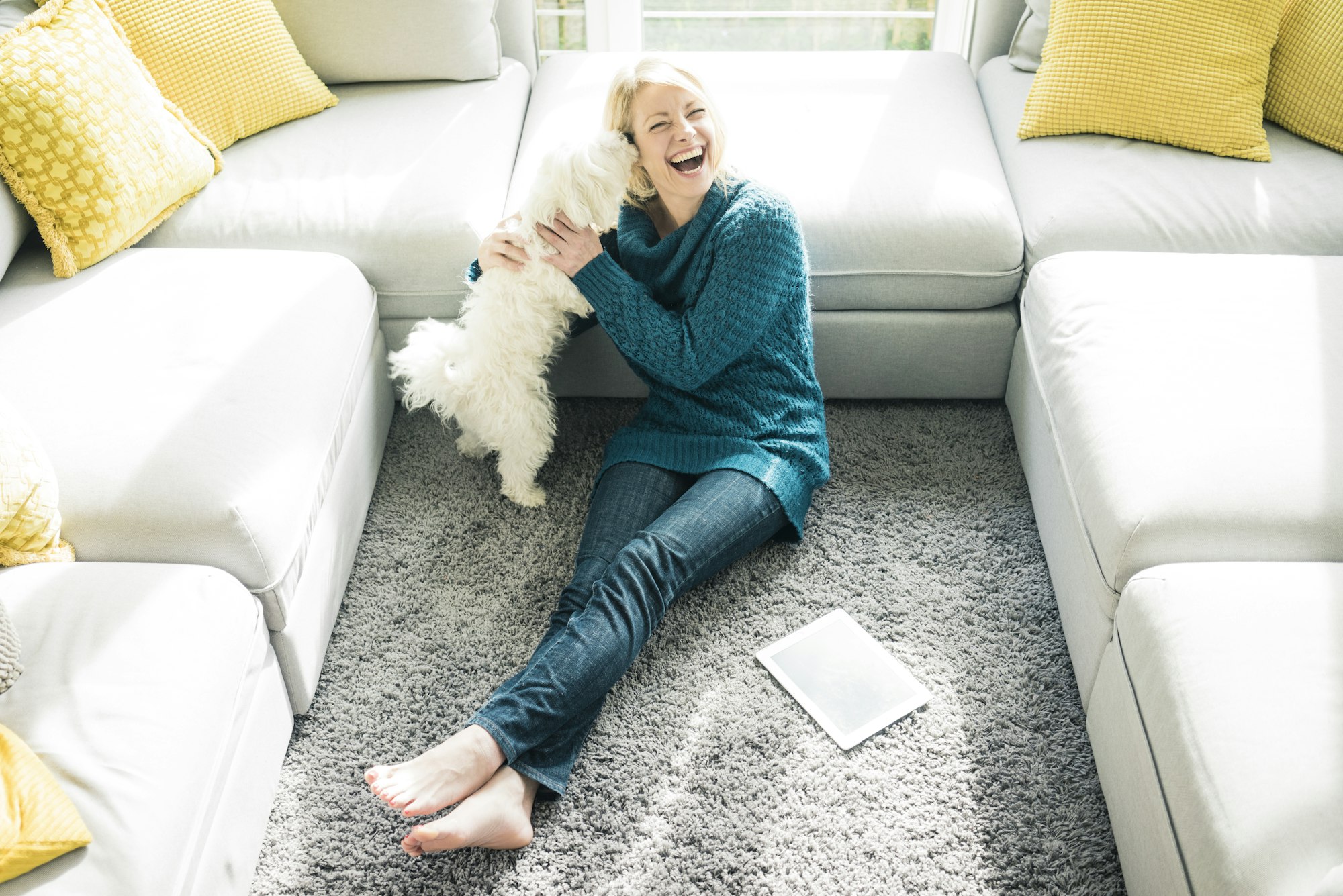 Playful woman with dog in living room